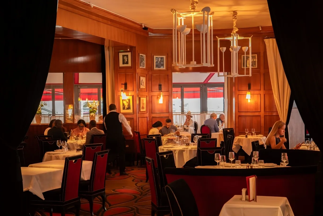 Het klassieke interieur van Le Fouquet's met rode banken en houten lambrisering