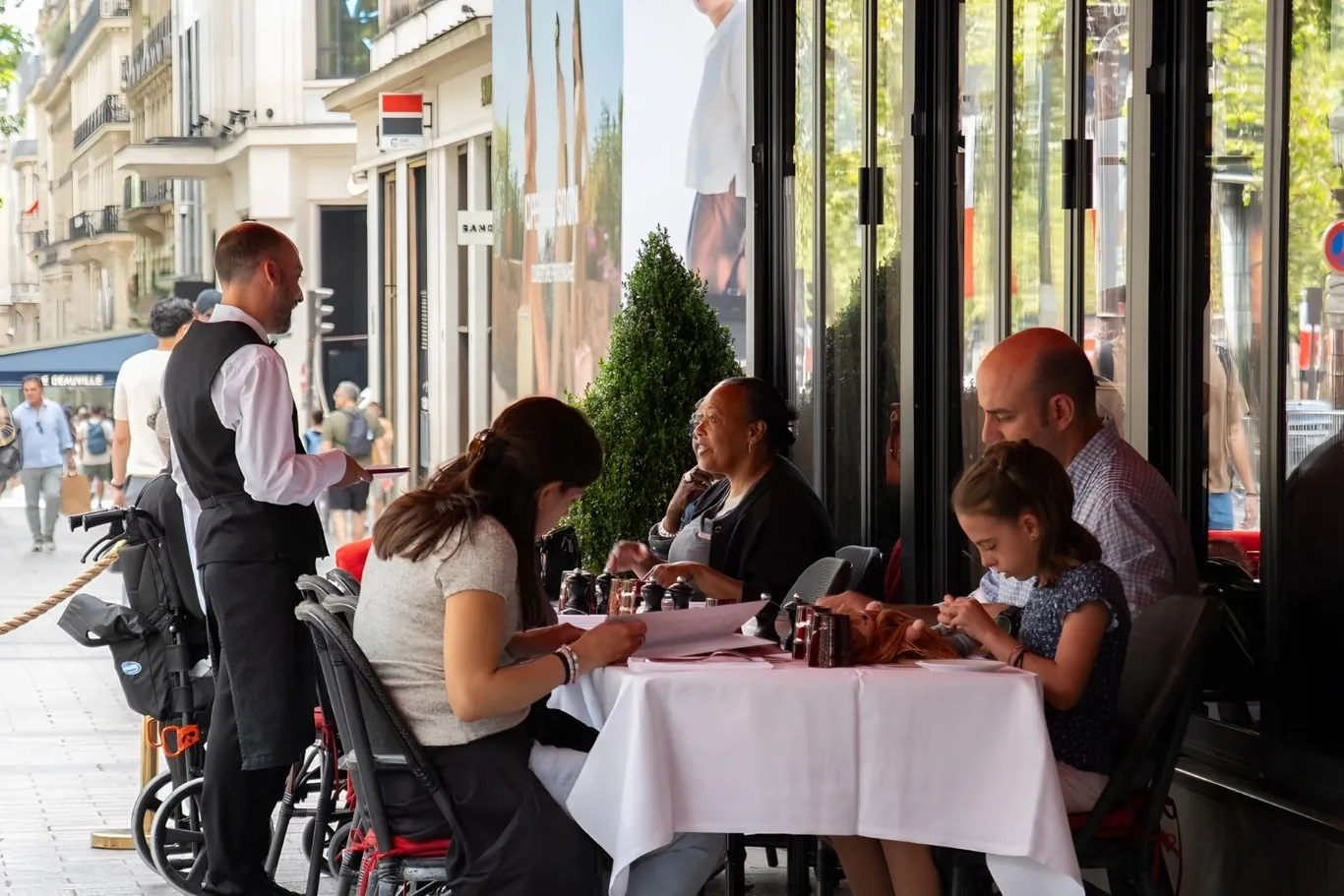 Ober bereidt een gerecht aan tafel bij Le Fouquet's