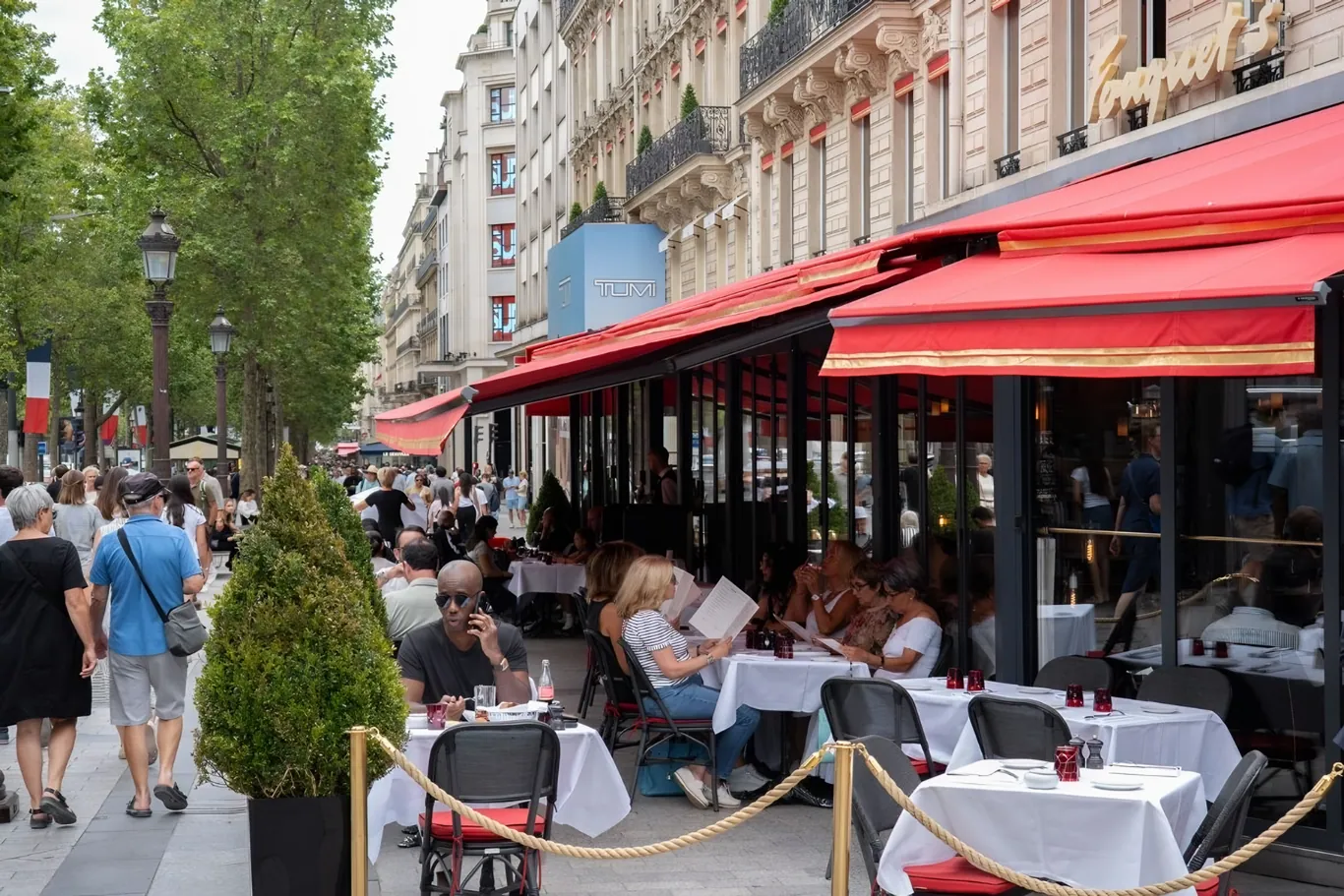 Het terras van Le Fouquet's aan de Champs-Élysées met rode stoelen en luifels