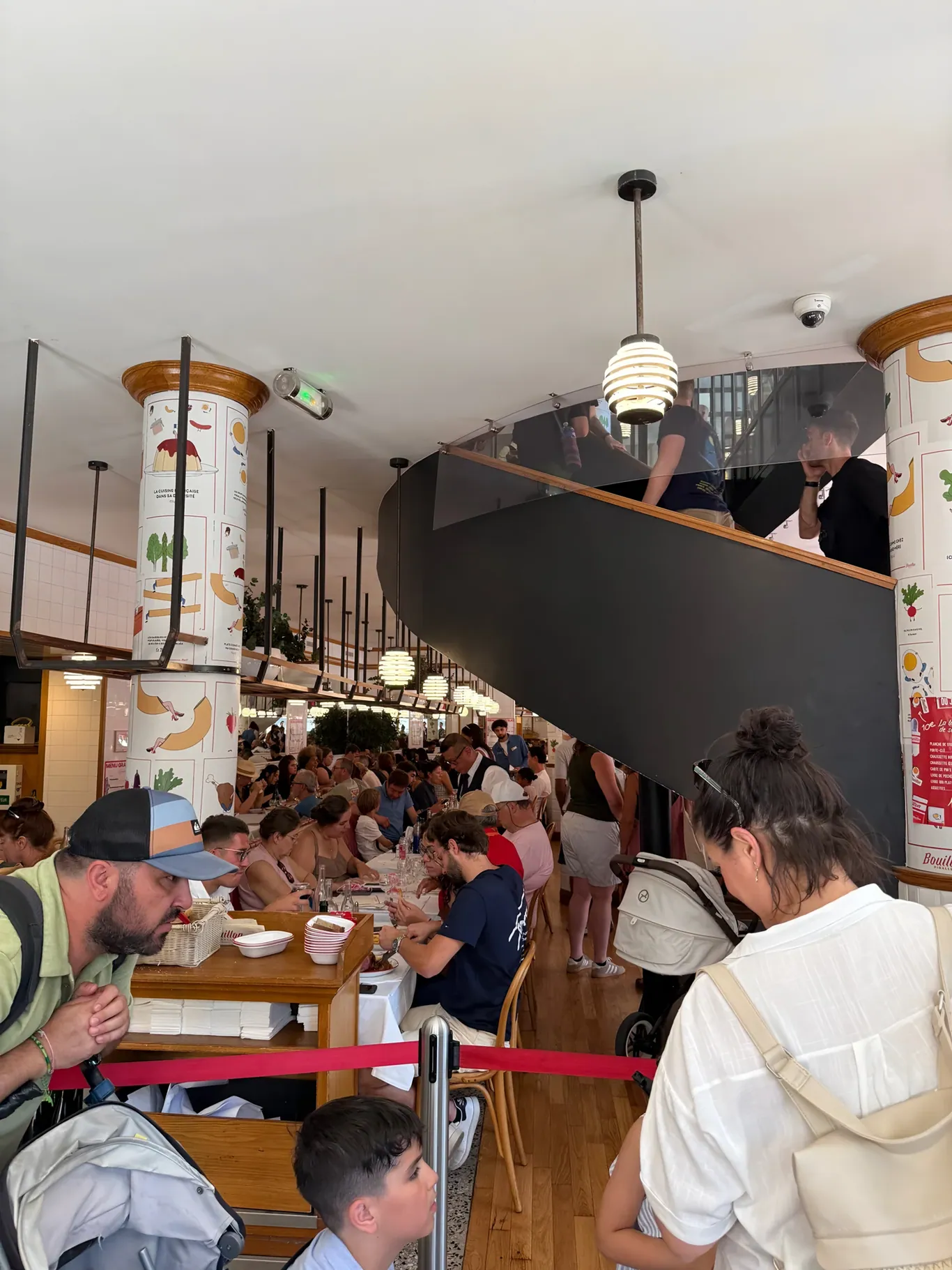 Drukke eetzaal met wenteltrap in Bouillon Pigalle in Parijs