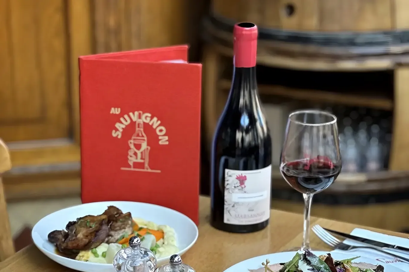 Wijn en gerechten op tafel bij Au Sauvignon in Parijs