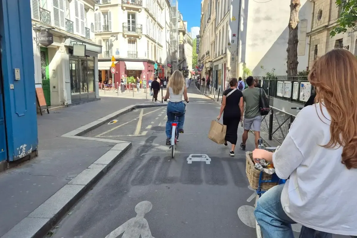 Fietsers en wandelaars in een winkelstraat in een Parijse wijk