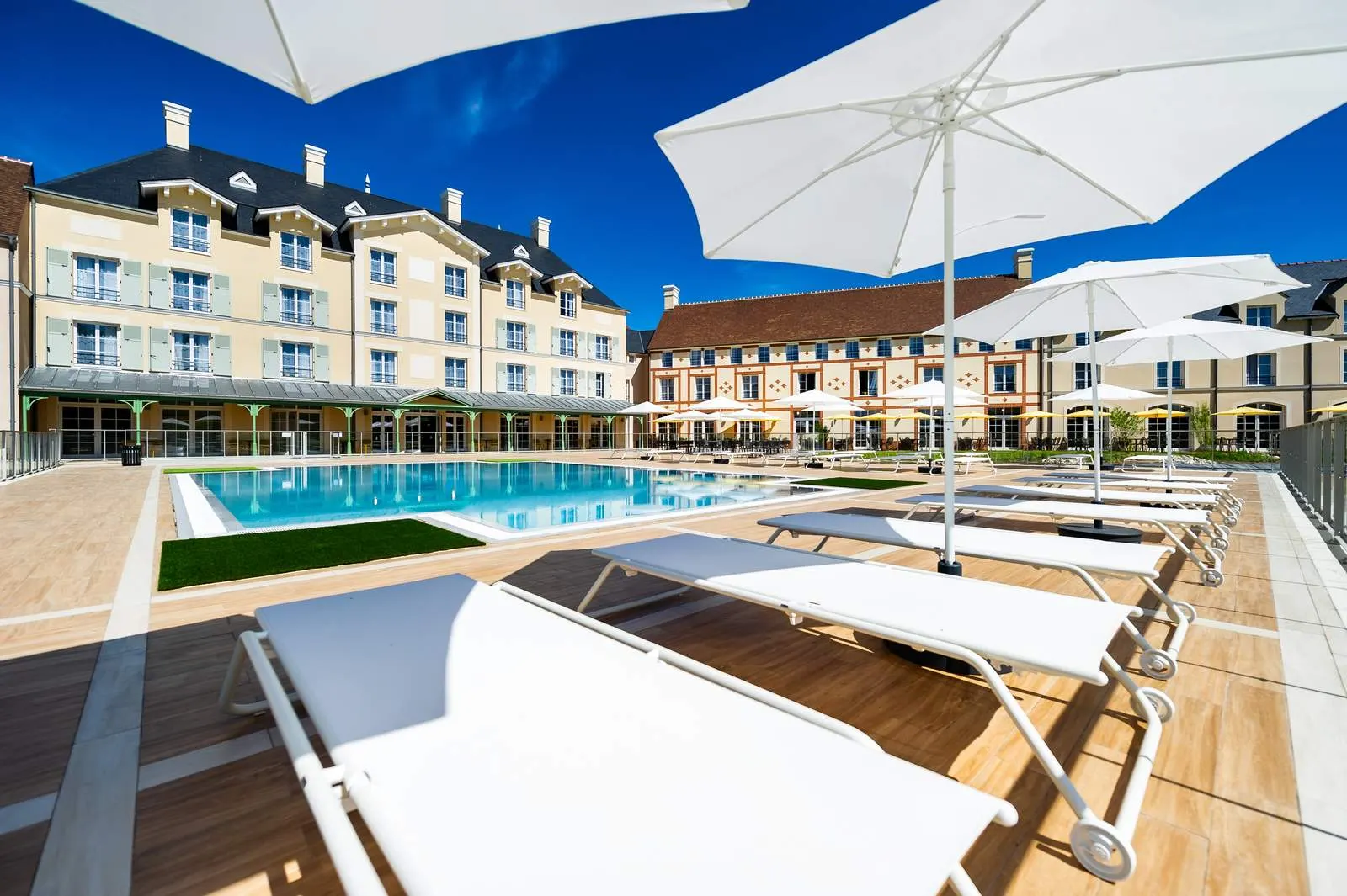 Het zwembad met ligbedden bij Staycity Aparthotel