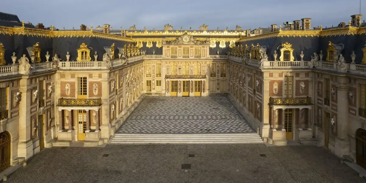 De marmeren binnenplaats van het paleis van Versailles bij avondlicht