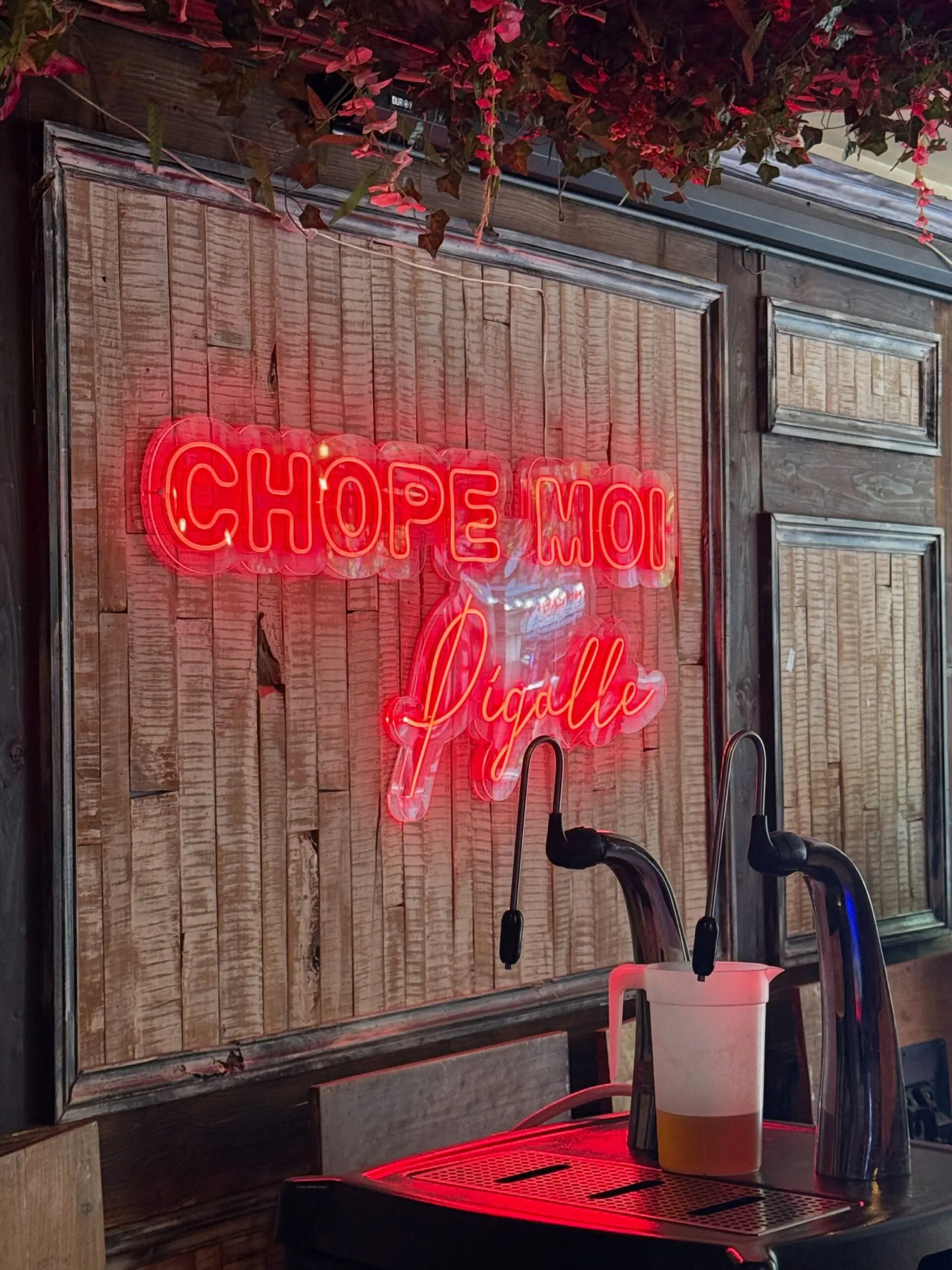 Neonbord met Chope Moi Pigalle aan de muur van de bar in Parijs