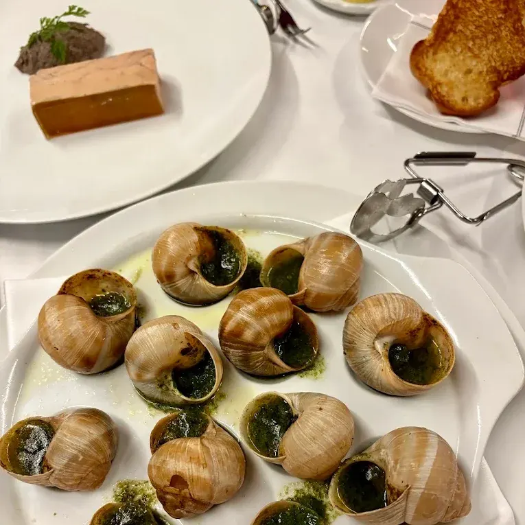 Escargots de Bourgogne met kruidenboter en een terrine van eendenlever bij Le Fouquet's in Parijs